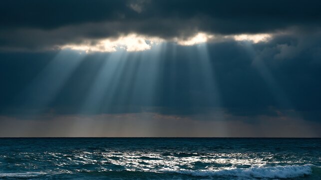 Rayons de soleil per&ccedil;ant les nuages sombres au-dessus de l'oc&eacute;an