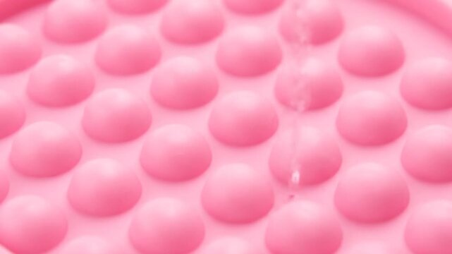 Close up of pink textured surface with raised bumps.