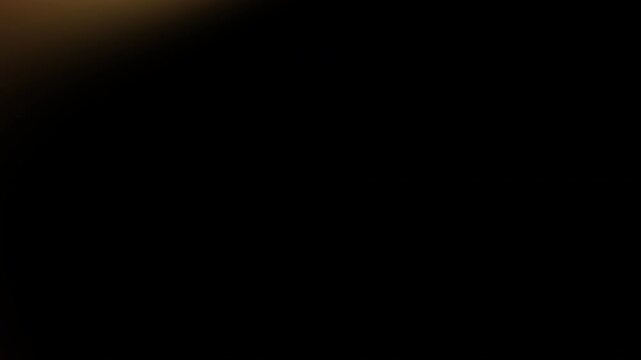 Warm golden orange light leak overlay featuring soft sweeping movement across dark background for intense cinematic transitions and elegant visual effects 4K UHD