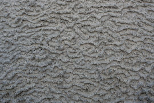 Abstract grey mortar texture with wavy grooves and organic ridge pattern for industrial background design