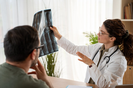 Doctor reviewing MRI spine scan with patient in medical office consultation