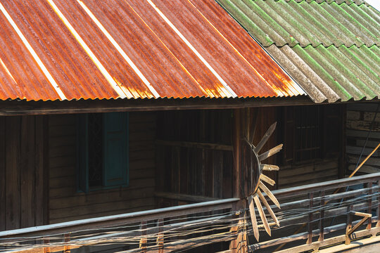 Old traditional wooden house balcony featuring unique sunburst wood carving decoration and designed to prevent people from climbing over balcony. Sunburst design by wood craft. Traditional lifestyle