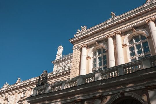 Elegant neoclassical architecture with tall columns and arched windows on clear blue sky