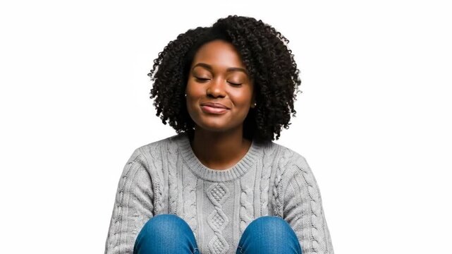 Smiling woman in cozy sweater and jeans against plain background
