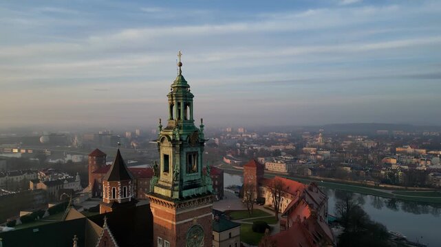 Wawel Castle towers at sunrise in Krakow Poland aerial viewBeautiful aerial drone shot of Wawel Castle towers during sunrise in Krakow, Poland. Historic royal castle above the city skyline in warm mor