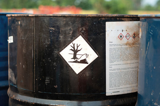 An environment hazard warning sign (GHS) on the chemical metal barrel. Safety sign for industrial product, close-up with selective focus.