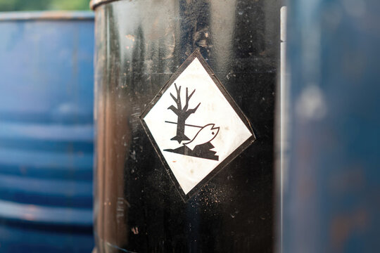 An environment hazard warning sign (GHS) on the chemical metal barrel. Safety sign for industrial product, close-up with selective focus.