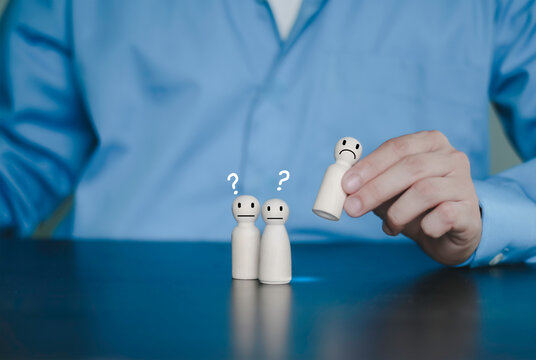 Hand picking specific wooden peg figure from a row. Recruitment process, candidate selection, choosing the right person for the job, promotion, and human resource management concept.