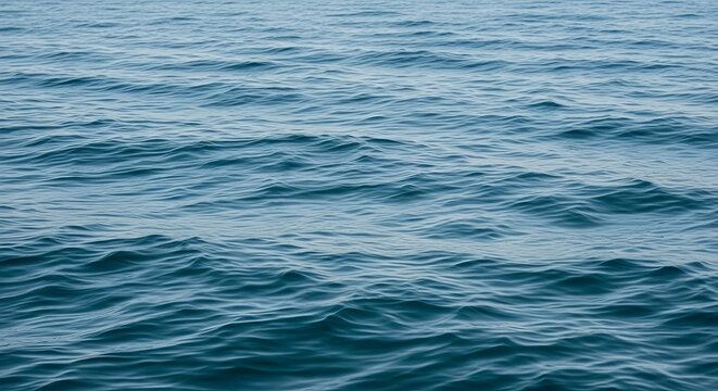 Detailed view of rippling blue ocean water surface with gentle waves and serene patterns