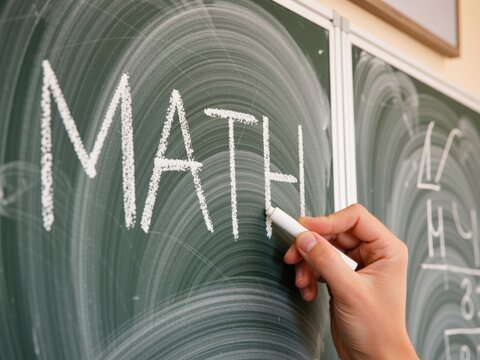 Hand writing math word using chalk on chalkboard