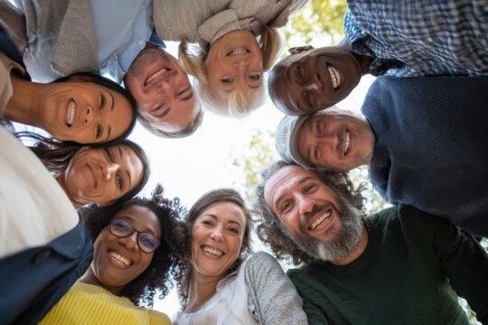 The Group of Smiling Diverse Adults in a Circle Looking Down at Camera