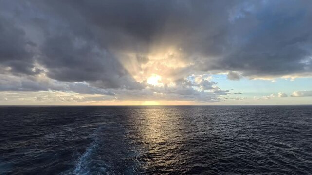 Vast sea expanse with dramatic skies and cruise ship wake
