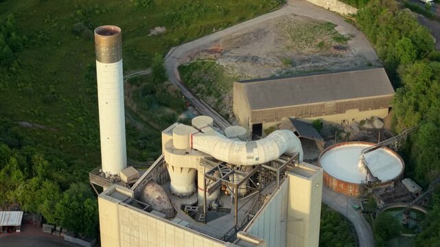 Aerial drone view of industrial kiln towers and chimney stacks at a large scale concrete production facility in Rugby UK