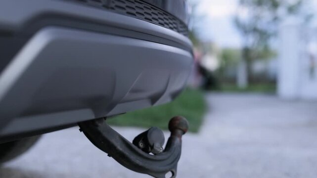 Towbar on a car, black steel part. Tow bar and tow ball on a car. Car detail. Foldable tow device switch. Extending and retractable towbar. Deployable Electric Tow Bar. Foldable tow device switch