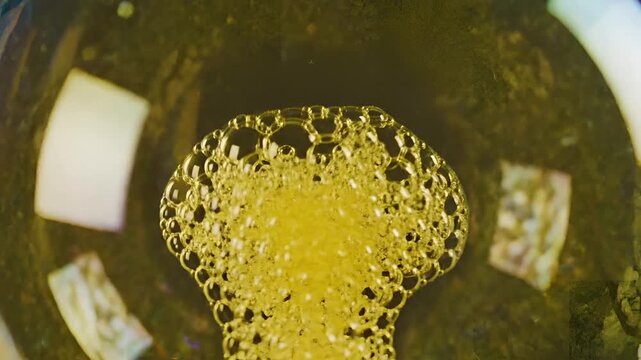 Closeup Macro View of Bubbles Forming in Yellow Liquid.