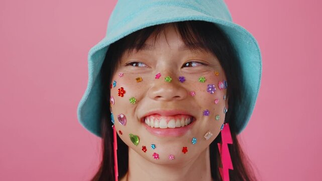 Beautiful asian woman portrait, young asian woman smiling with face stickers and pink background