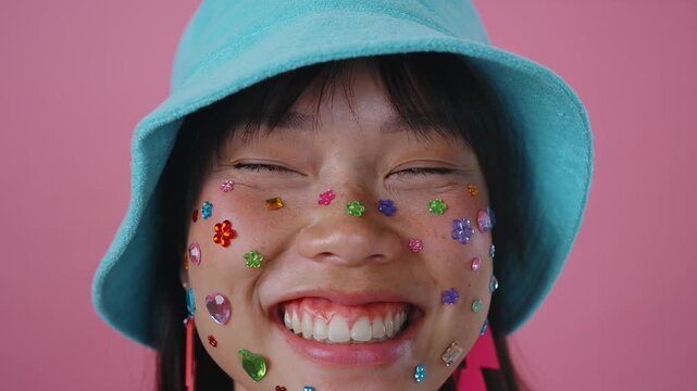 Beautiful asian woman portrait, young asian woman smiling with face stickers and pink background