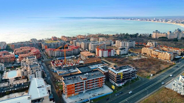 Traditional wooden houses and cobblestone street in old town Nesebar. Daytime view of historic wooden buildings with terracotta tile roofs along a narrow cobblestone street under bright sky.