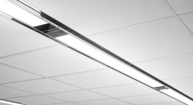 Polished chrome linear diffuser strip providing bright overhead illumination in a modern suspended ceiling office environment.