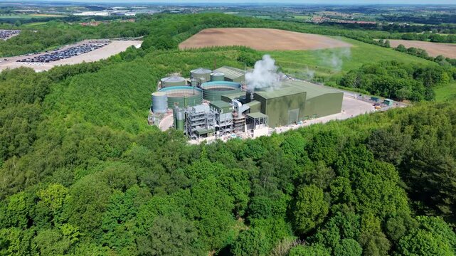 High angle aerial drone view of a large anaerobic digestion facility producing biogas and renewable electricity for the national grid near Atherstone Warwickshire UK