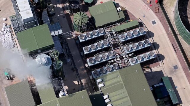 High angle aerial drone view close up of spinning cooling fans on an industrial radiator table at a green biogas renewable energy plant near Tamworth UK