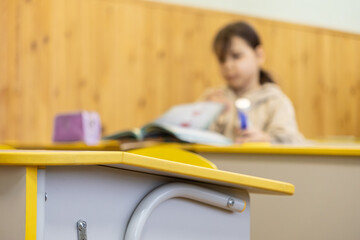 Obraz premium Schoolchild studying in a bright classroom at a desk, representing primary education, academic progress, focus on learning, knowledge acquisition and childhood development concepts