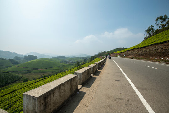 A breathtaking panoramic view of Munnar's unique topography, characterized by an endlessly rolling terrain of deep green valleys.