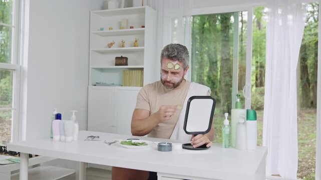 Facial cream treatment in male spa routine. Man applying moisturizing facial cream on face. Male dermatology care with anti aging facial cream. Natural facial cream for men skincare routine.