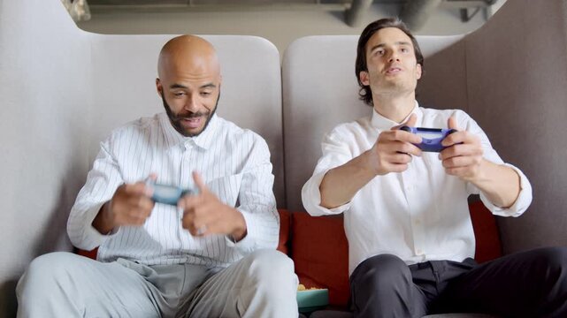 Two colleagues immerse themselves in a thrilling gaming session during a work break, sharing laughter and excitement as they cheer each other on, fostering friendship in a relaxed office setting