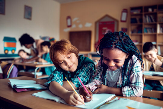 Elementary students collaborating on homework in classroom