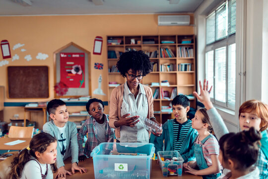 Teacher leading children in recycling lesson in classroom