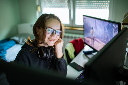 Smiling teen gamer playing pc in bedroom