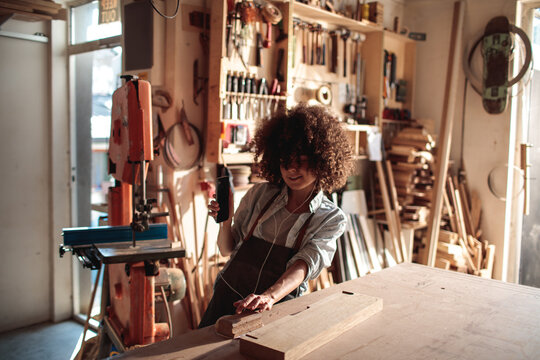 Artisan sanding wood in sunny workshop