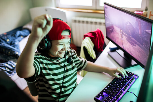 Young gamer celebrating victory on pc at home