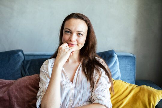 Smiling woman relaxing on sofa at home