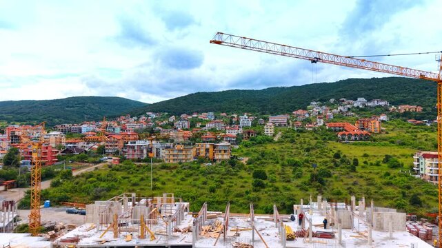 Concrete framework of multi-story resort hotel building development. Monolithic concrete structure of a resort hotel under development with heavy equipment on site.