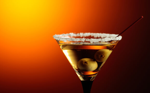 Glass of Martini with green olives.