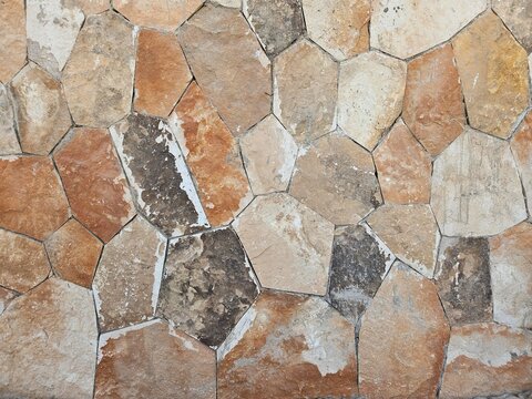 Texture of a natural stone wall with irregular shapes. Brown, beige and orange slate masonry background
Seamless pattern of rustic flagstone wall cladding. Natural earthy tones stone pavement texture 