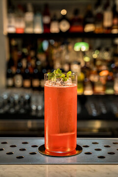 cocktail rojo listo para tomar con fondo de barra