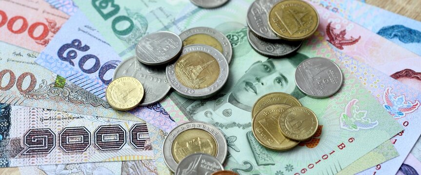Thai baht money bills and coins on table. Thailand cash of THB currency close up