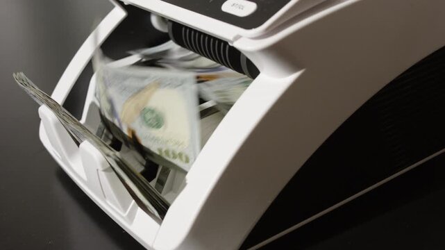 Counting dollar bills. Cash counting machine working with USD. Money counting process. Business and finance. Cash counting machine in motion. Investment and banking concept with count money.