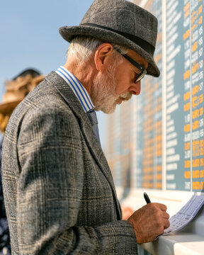 Bookmaker writing a betting ticket at an outdoor horse racing betting stand