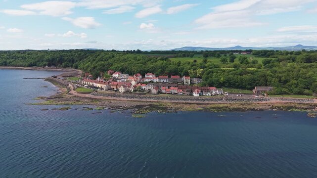 Drone flight approaching the historic village of West Wemyss in Fife, Scotland. Scenic coastal landscape featuring traditional architecture along the Firth of Forth.