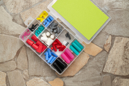 Assortment of silicone rubber tapered plugs and caps in a clear plastic storage box.