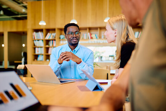 Group of multi-ethnic professionals discussing new strategies and project ideas in a modern office environment