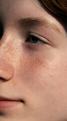 Fototapeta premium Sunlit face closeup, freckled skin, eye, nose, cheek, skin texture
