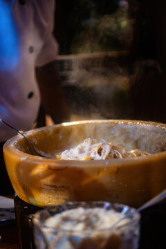 Pasta preparation with chef at restaurant during evening service