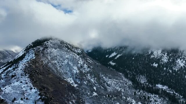 Aerial shot of the clouds and the rugged terrain of the Wasatch Mountains near Salt Lake City, Utah.