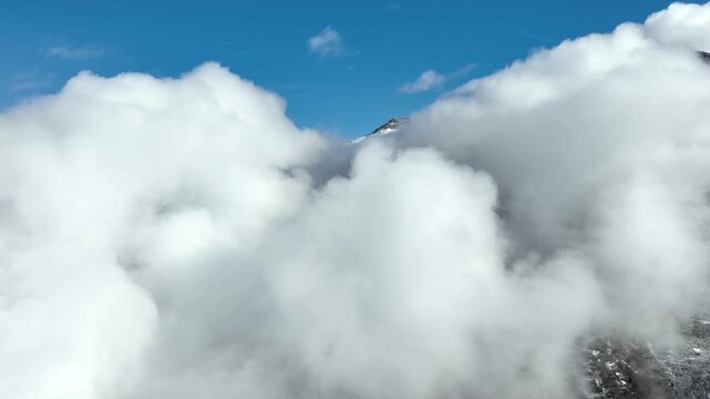 Aerial shot of the clouds and the rugged terrain of the Wasatch Mountains near Salt Lake City, Utah.