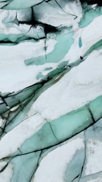 Aerial of a frozen lake and rugged landscape of Norway. Vertical Video.
